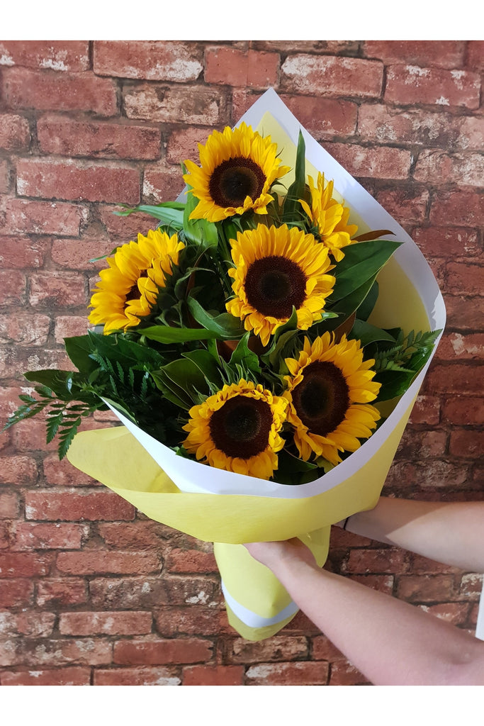 Give someone a sunny mix of Sunflowers and lush foliage.